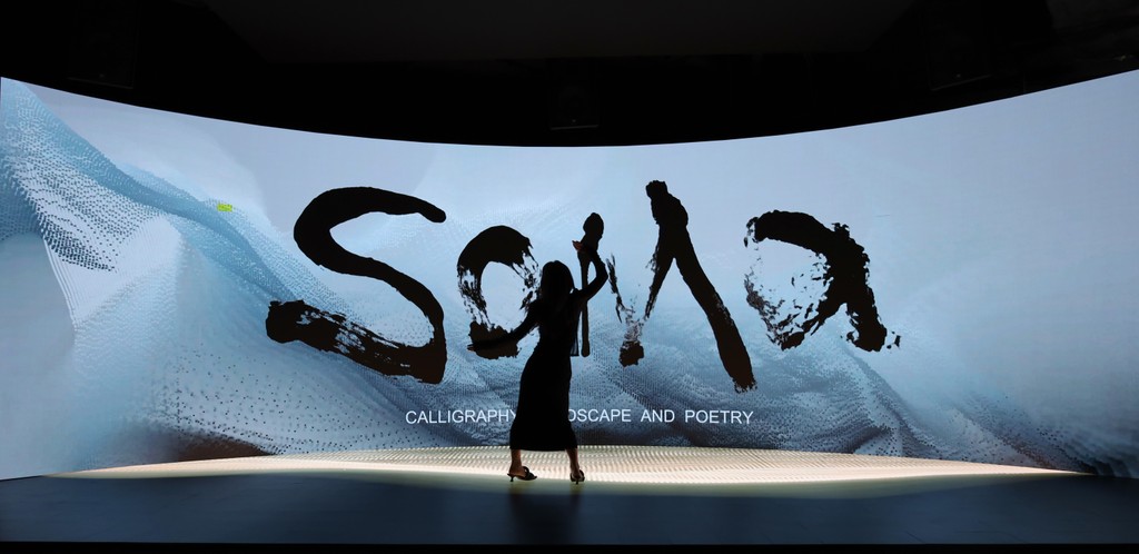 A participant in front of SOMA’s immersive calligraphy and landscape installation